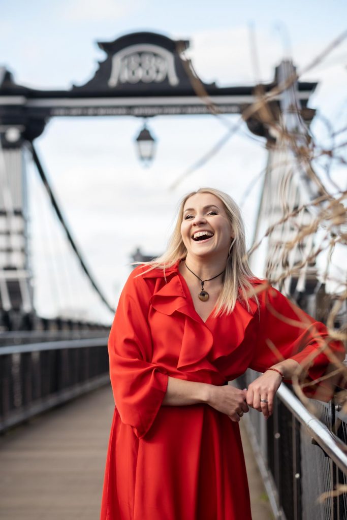 blond woman in a red dress laughing