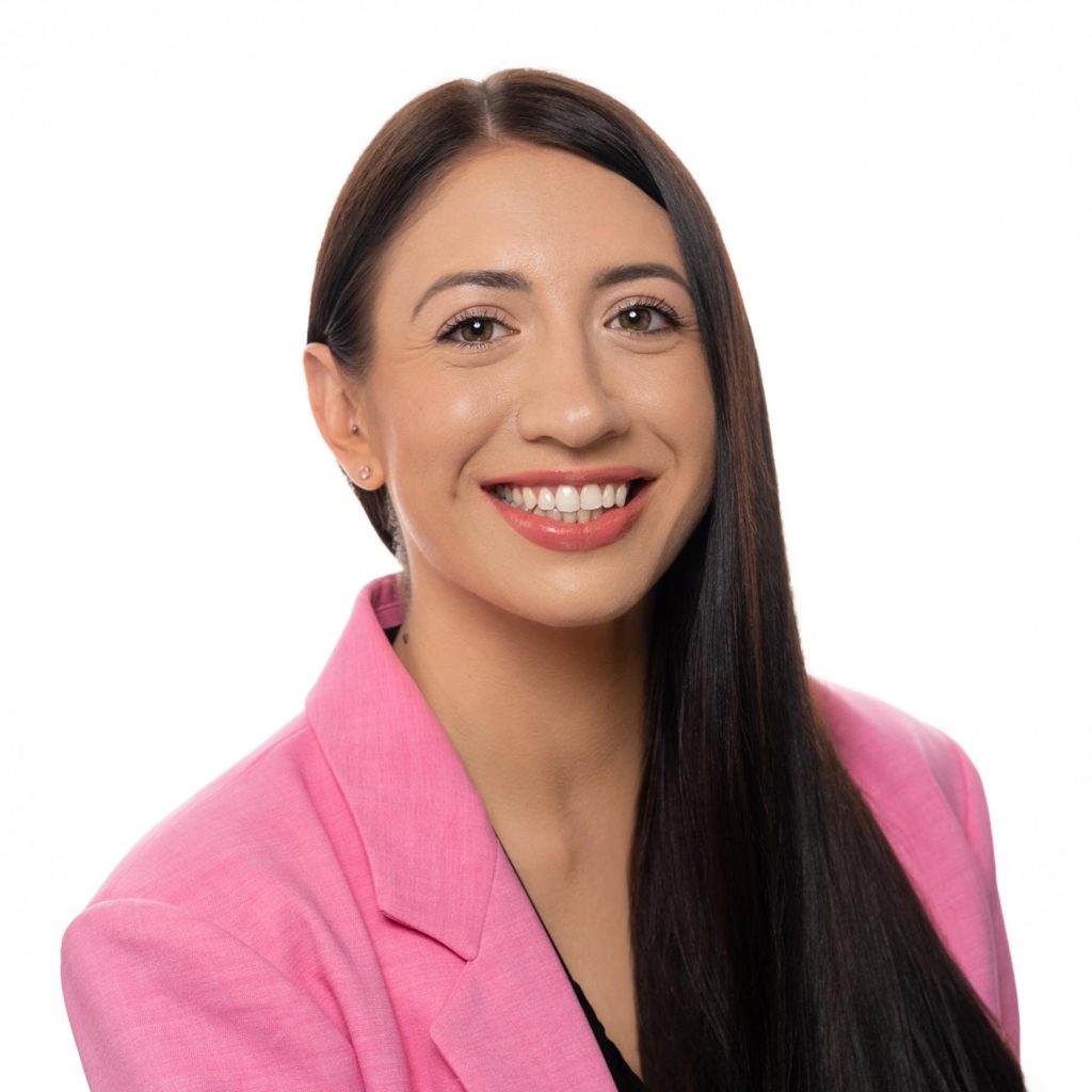 professional corporate headshot of a woman in pink blazer smiling