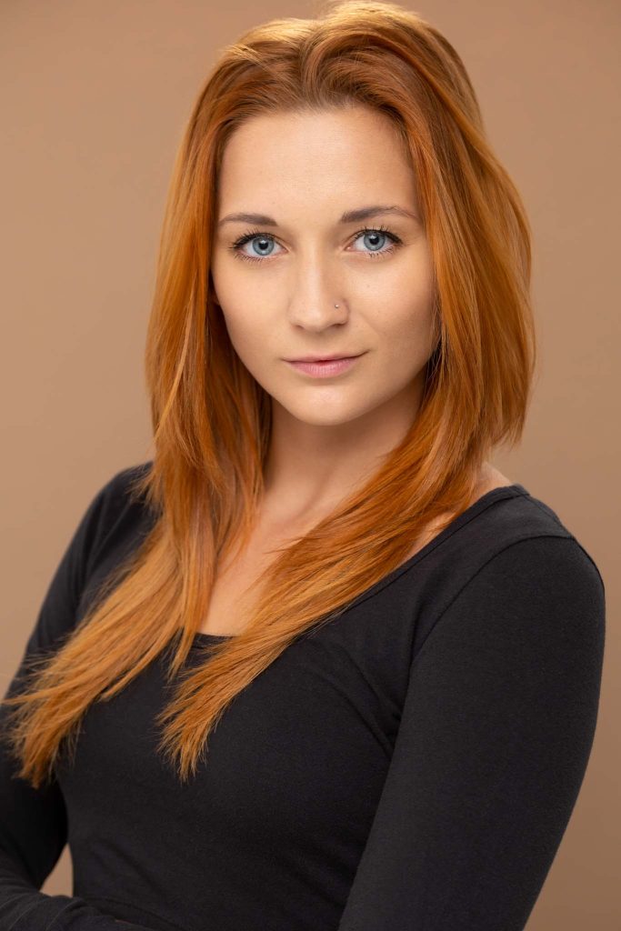 professional headshot of a red hair female performer and model