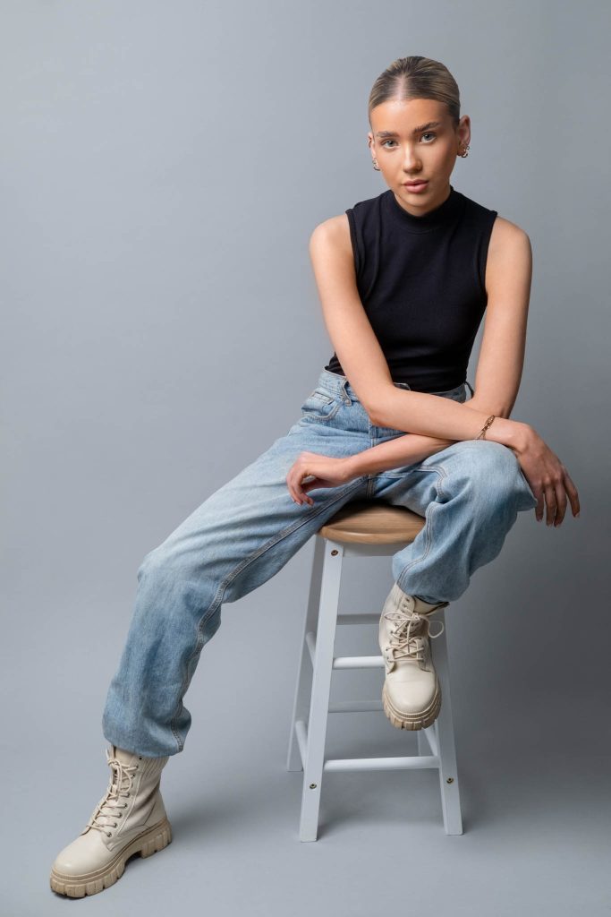 female model posing on a stool modelling street wear