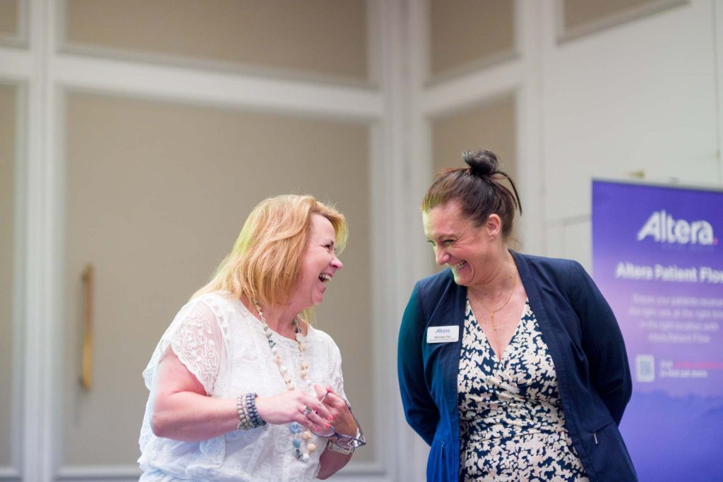 keynote speakers laughing whilst presenting at a conference. Corporate event photography Birmingham UK