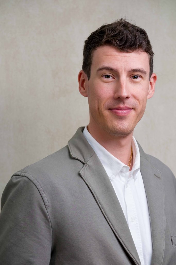 studio corporate headshot of a man smiling