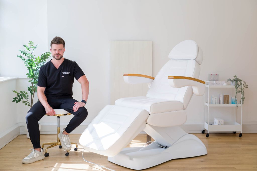 An aesthetic doctor posing for a photo at his clinic and smiling. Aesthetic clinic brand photoshoot in Birmingham UK