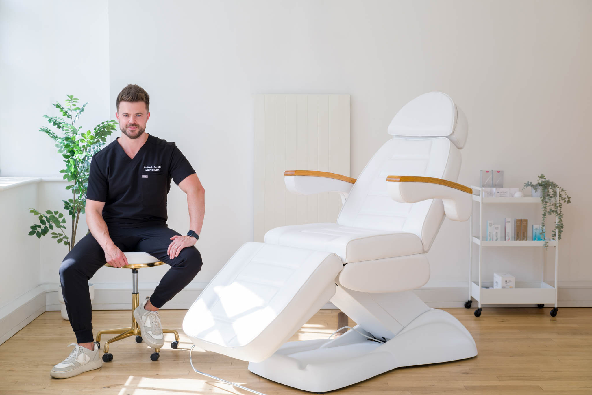 An aesthetic doctor posing for a photo at his clinic and smiling. Aesthetic clinic brand photoshoot in Birmingham UK