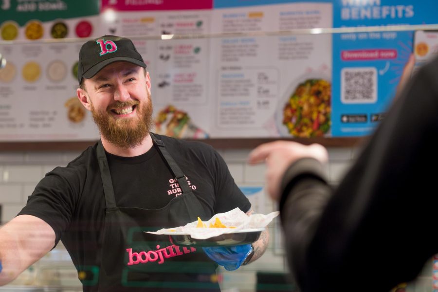 restaurant marketing photography, smiling staff member is serving customers